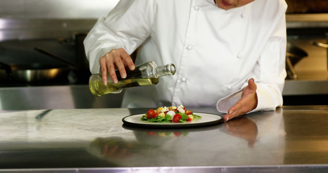 Chef Preparing Gourmet Salad with Olive Oil in Professional Kitchen - Free Images, Stock Photos and Pictures on Pikwizard.com