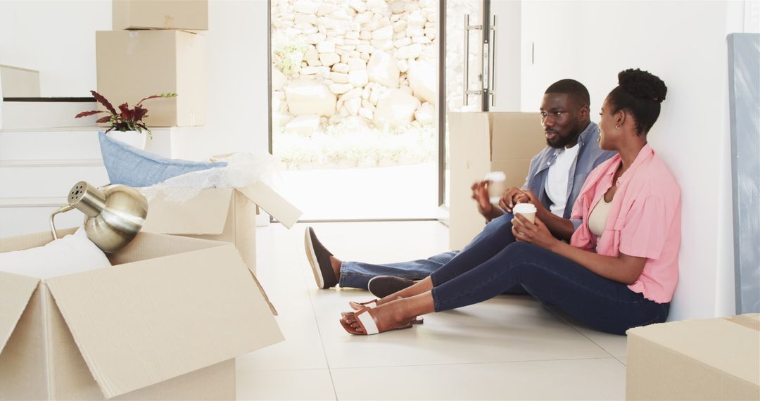 Couple Enjoying Coffee Amidst Moving Boxes in New Home