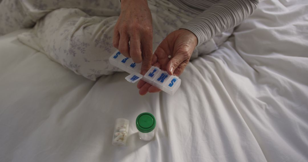 Senior sorting medication in weekly pill organizer - Free Images, Stock Photos and Pictures on Pikwizard.com