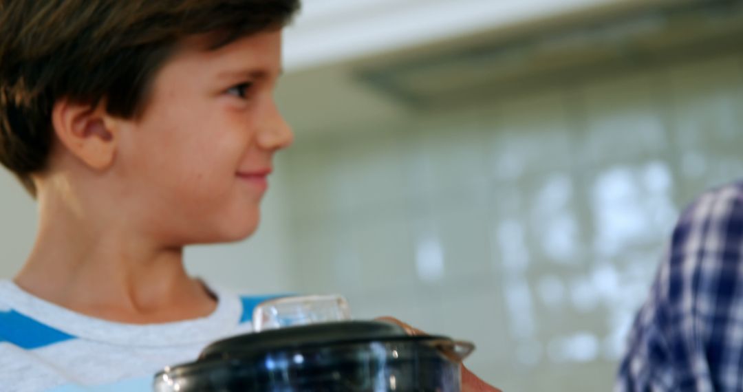 Smiling Boy Holding Blender Container in Kitchen - Free Images, Stock Photos and Pictures on Pikwizard.com