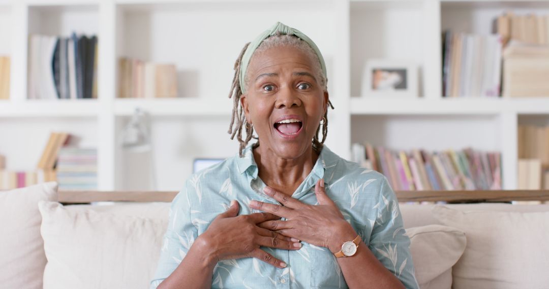 Senior Woman Reacting with Surprise While Sitting on Couch - Free Images, Stock Photos and Pictures on Pikwizard.com