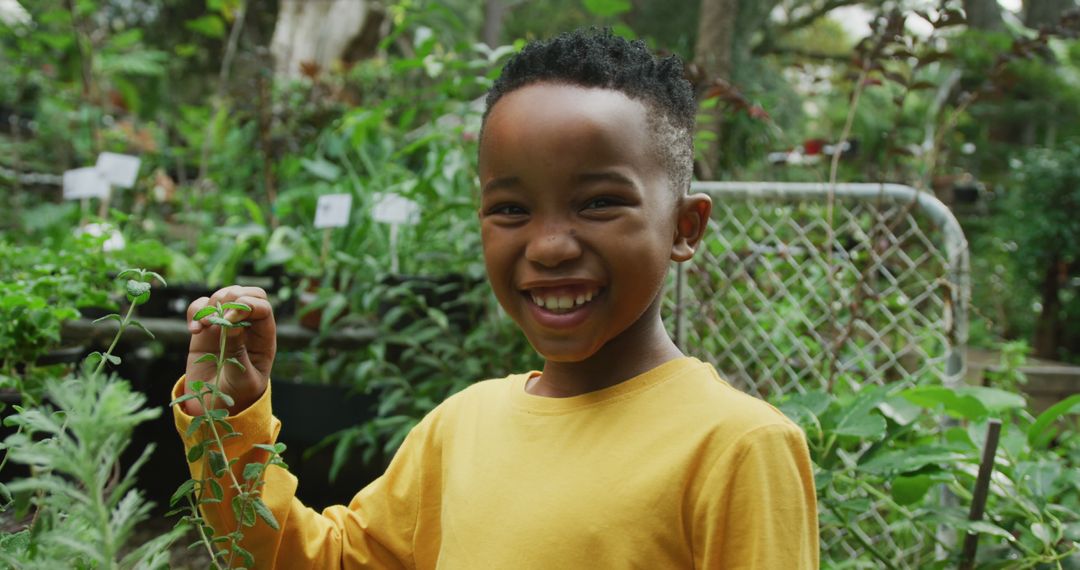 Portrait of happy african american boy looking at plants and smiling in garden - Free Images, Stock Photos and Pictures on Pikwizard.com