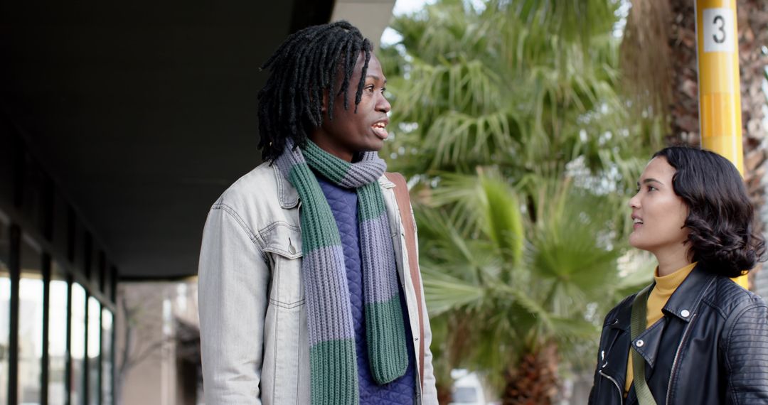 Multicultural Couple Chatting at Transit Stop Wearing Denim and Leather Jackets