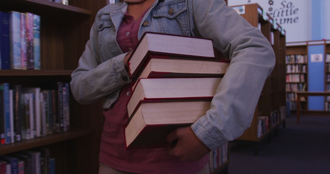 Person Holds Stack of Books in Library - Free Images, Stock Photos and Pictures on Pikwizard.com