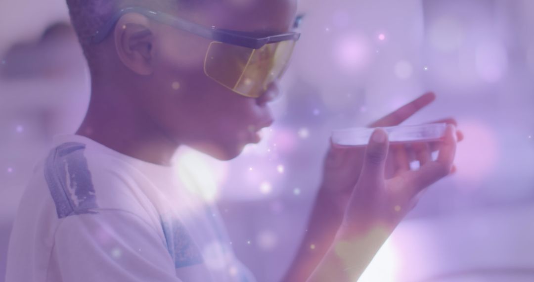 Young Boy Examining Petri Dish Science Experiment with Digital Light Effects