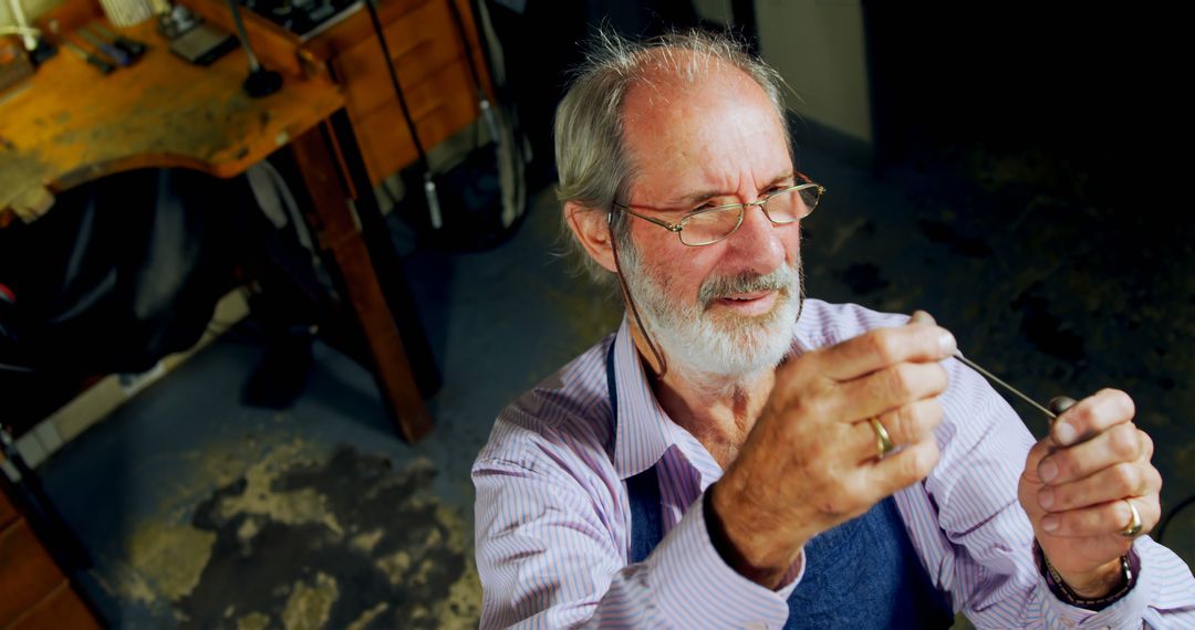 Senior Jewelry Artisan Inspecting Craftsmanship in Workshop - Free Images, Stock Photos and Pictures on Pikwizard.com