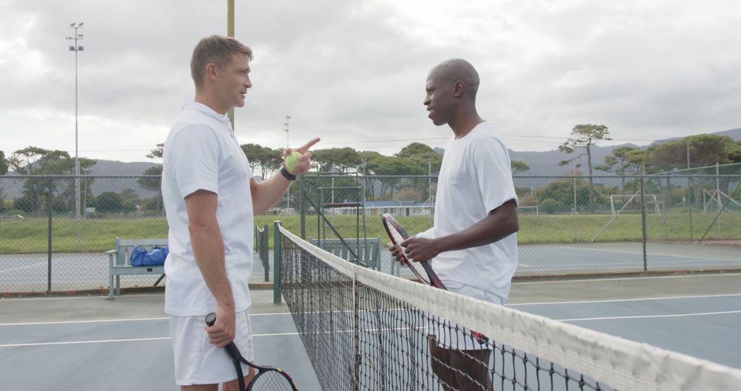 Two Male Tennis Players Preparing for Friendly Match on Outdoor Court - Free Images, Stock Photos and Pictures on Pikwizard.com