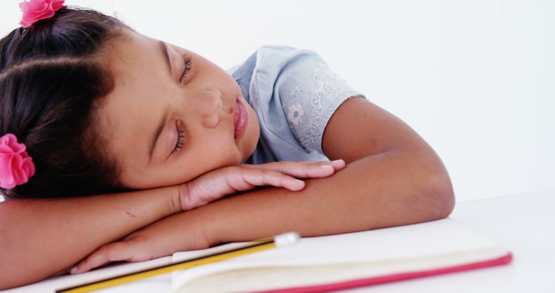 Young Girl Sleeping on Desk While Studying with Peaceful Expression