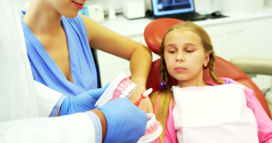 Dentist Teaching Dental Hygiene to Young Girl at Clinic - Free Images, Stock Photos and Pictures on Pikwizard.com