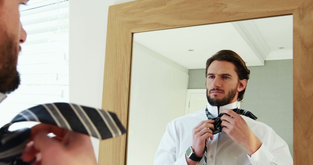 Man Tying Tie in Front of Mirror, Getting Ready for Work - Free Images, Stock Photos and Pictures on Pikwizard.com