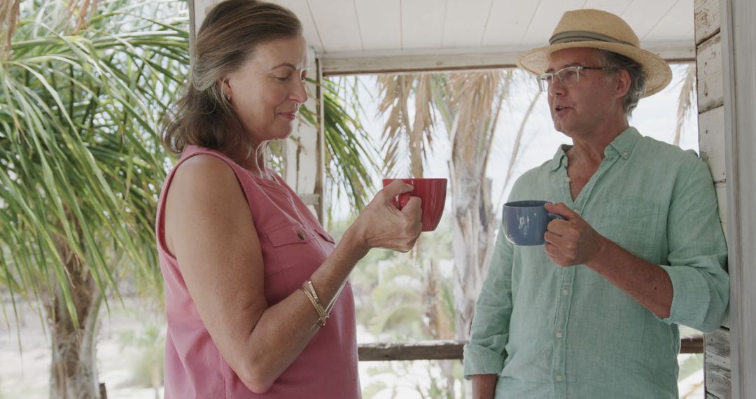 Senior Couple Enjoying Coffee on Tropical Balcony - Free Images, Stock Photos and Pictures on Pikwizard.com