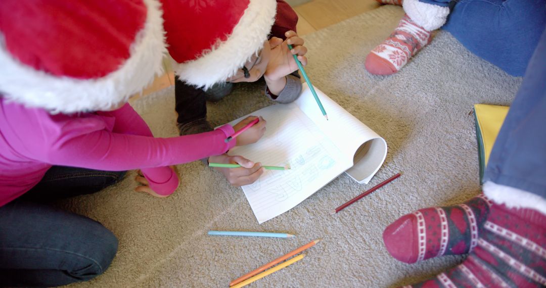 Children Drawing with Colored Pencils Wearing Santa Hats during Holidays - Free Images, Stock Photos and Pictures on Pikwizard.com