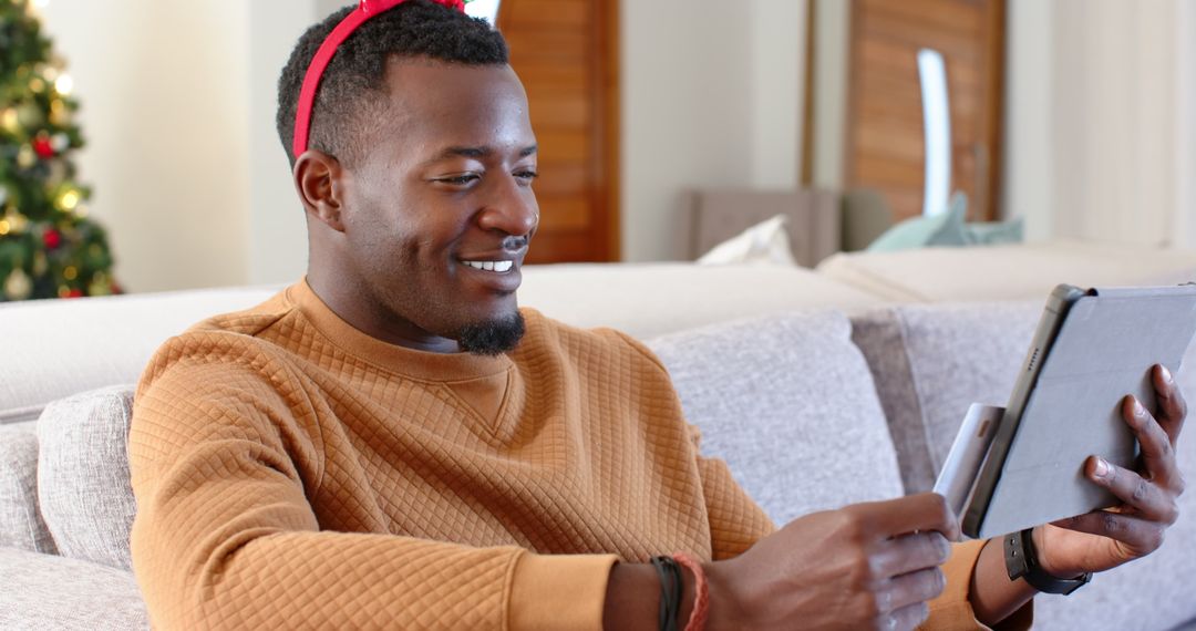 Smiling Man Online Shopping with Tablet During Holidays at Home