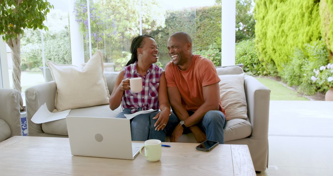 Smiling Couple Enjoying Relaxed Moment at Home with Laptop