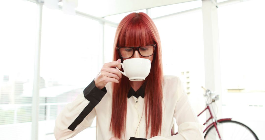 A Caucasian woman with red hair is sipping coffee from a white cup, with copy space - Free Images, Stock Photos and Pictures on Pikwizard.com