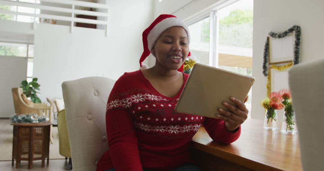 Smiling Woman with Santa Hat Video Calling on Tablet During Christmas - Free Images, Stock Photos and Pictures on Pikwizard.com