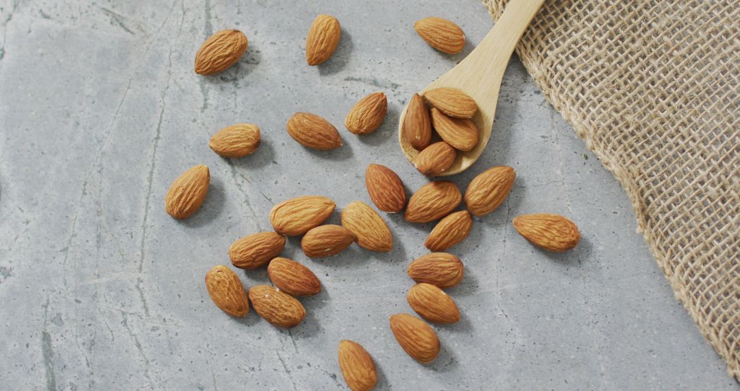 Raw Almonds on Stone Surface with Burlap Fabric