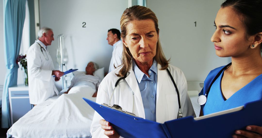 Healthcare Professionals Discussing Patient Records in Hospital Room - Free Images, Stock Photos and Pictures on Pikwizard.com