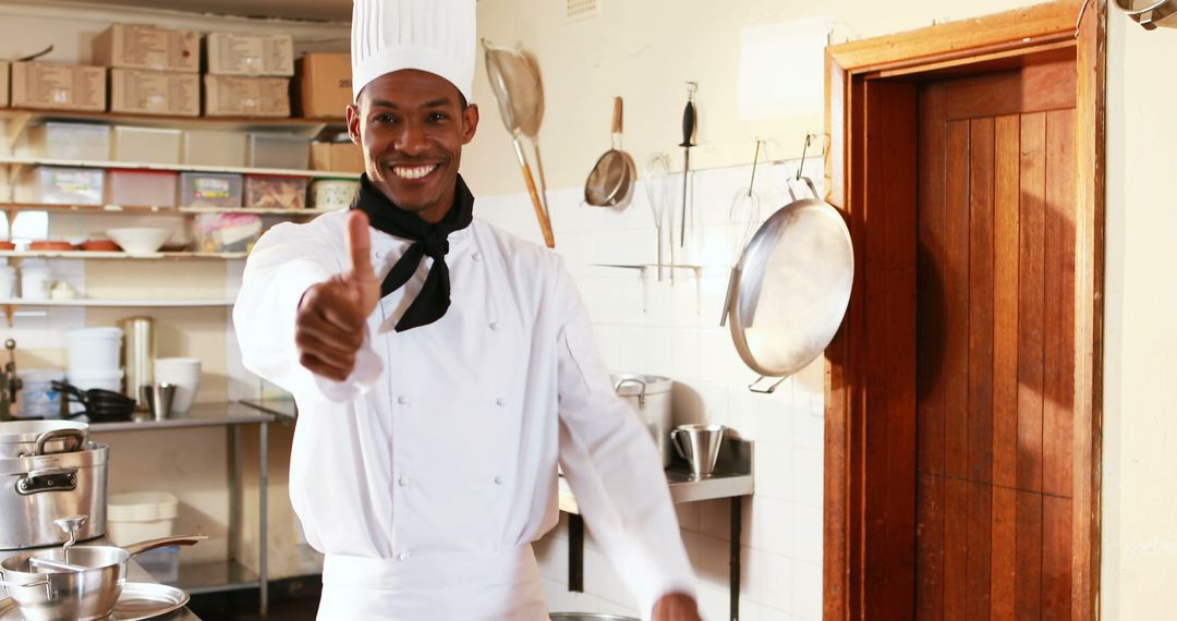 Smiling chef in kitchen giving thumbs-up - Free Images, Stock Photos and Pictures on Pikwizard.com