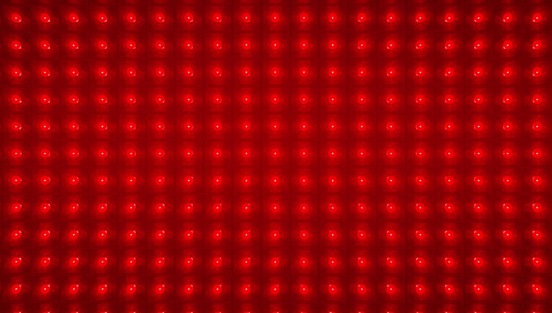Glowing Red LED Matrix Panel Forming Repeating Grid of Circular Emitters Macro Texture
