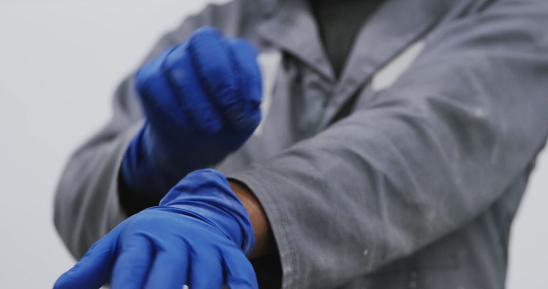 Scientist Wearing Protective Gear Adjusting Blue Gloves for Safety - Free Images, Stock Photos and Pictures on Pikwizard.com