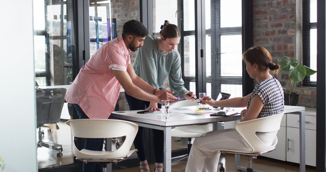 Team Analyzing Document on Tablet During Collaborations in Modern Office