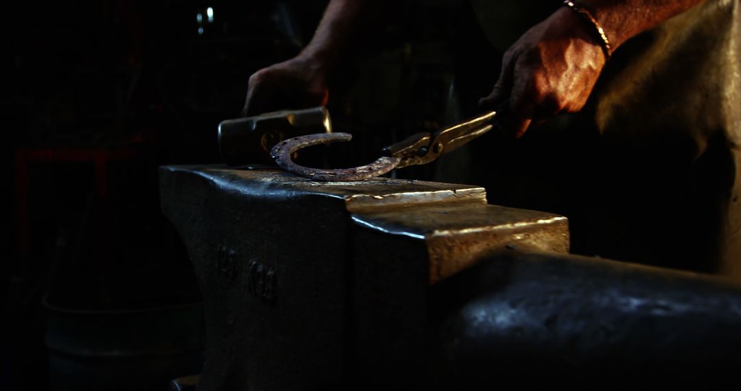 Skilled Blacksmith Forging Horseshoe in Workshop