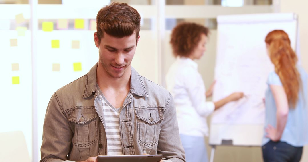 Young Professional Using Tablet in Collaborative Office Environment