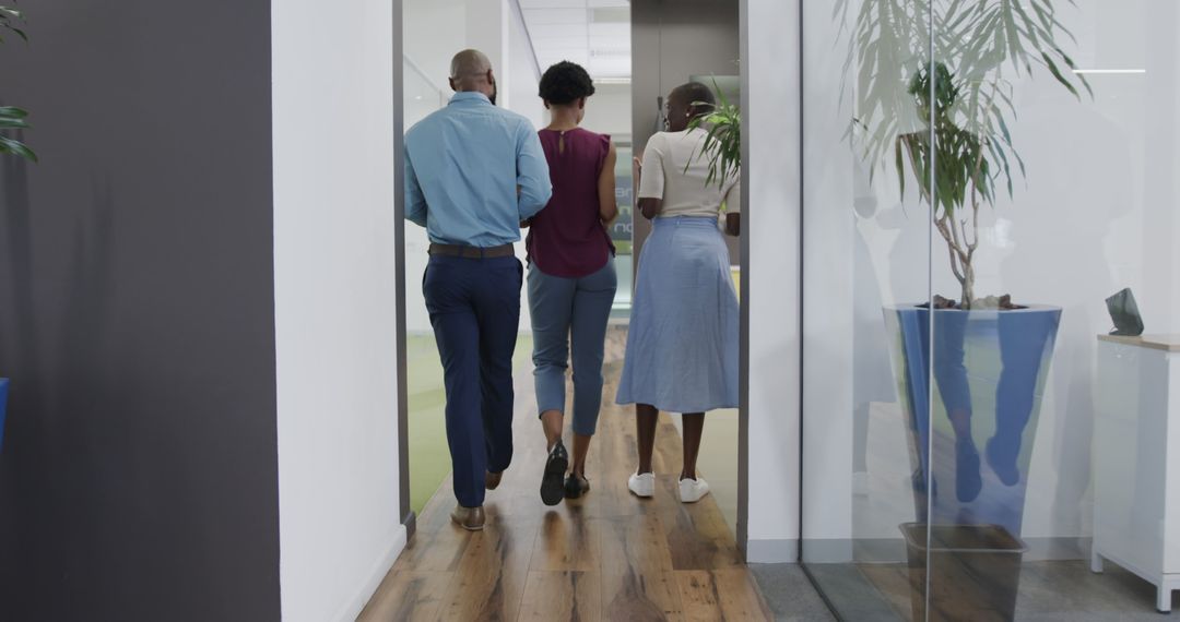 Colleagues Walking Down Hallway in Modern Office - Free Images, Stock Photos and Pictures on Pikwizard.com