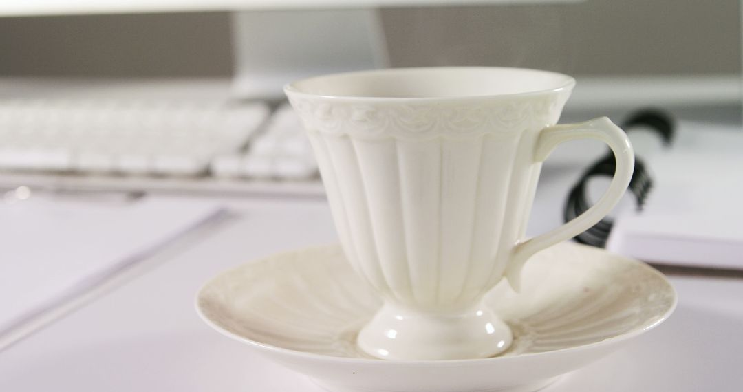 Elegant White Tea Cup on Desk Near Computer Keyboard - Free Images, Stock Photos and Pictures on Pikwizard.com