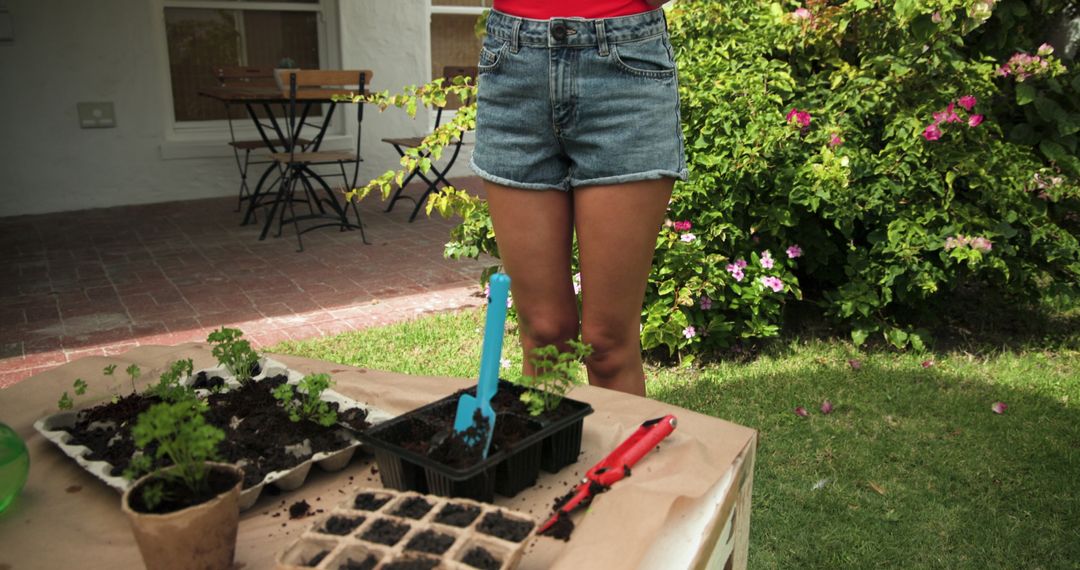 Gardener Preparing Seedling Trays on Patio Table in Lush Backyard