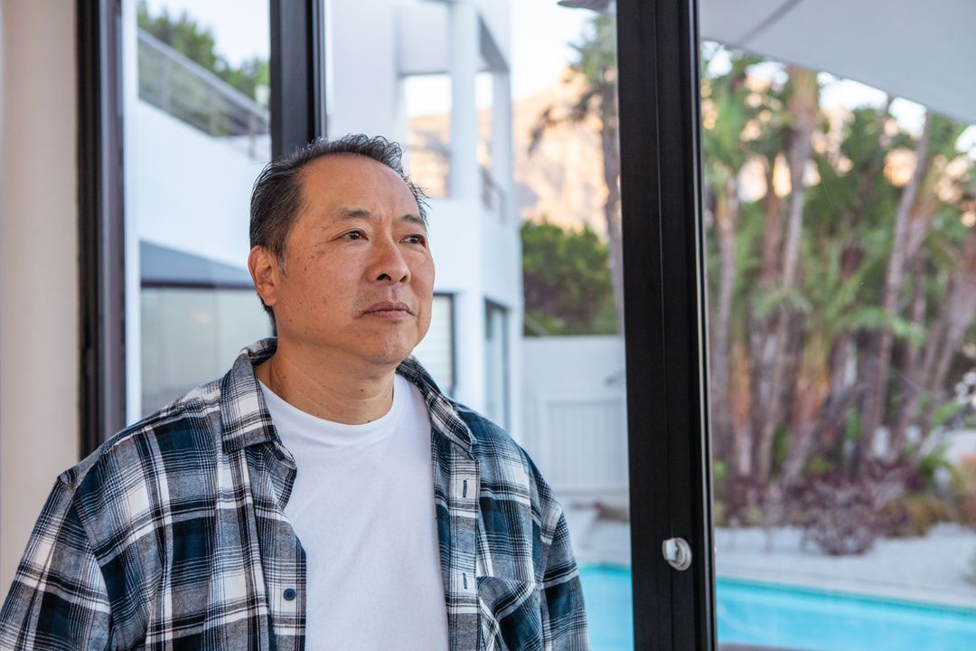 Man Relaxing at Modern Home Overlooking Poolside Serenity