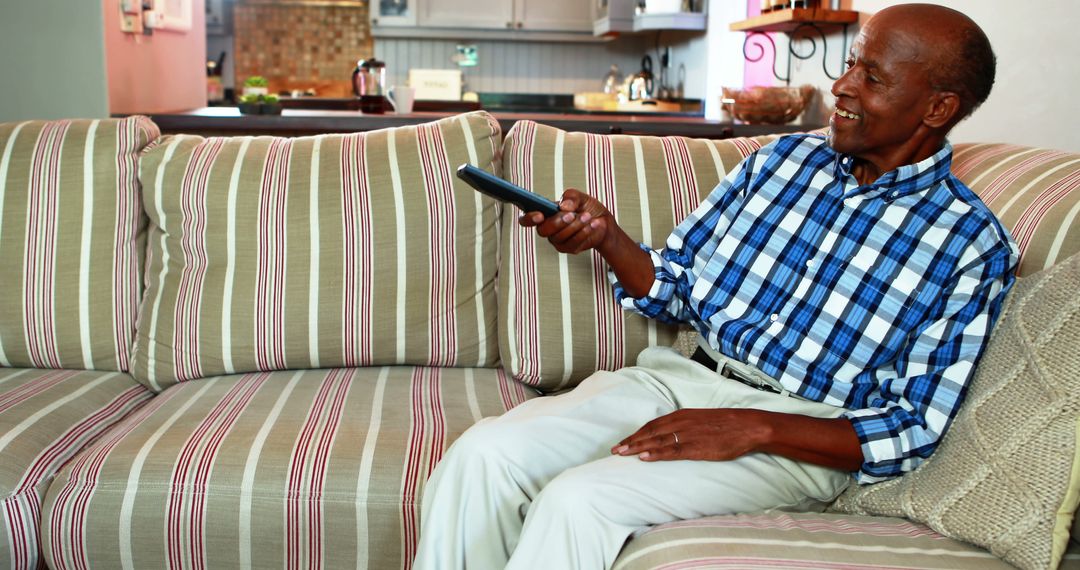 Senior Man Relaxing on Couch Watching Television in Living Room - Free Images, Stock Photos and Pictures on Pikwizard.com