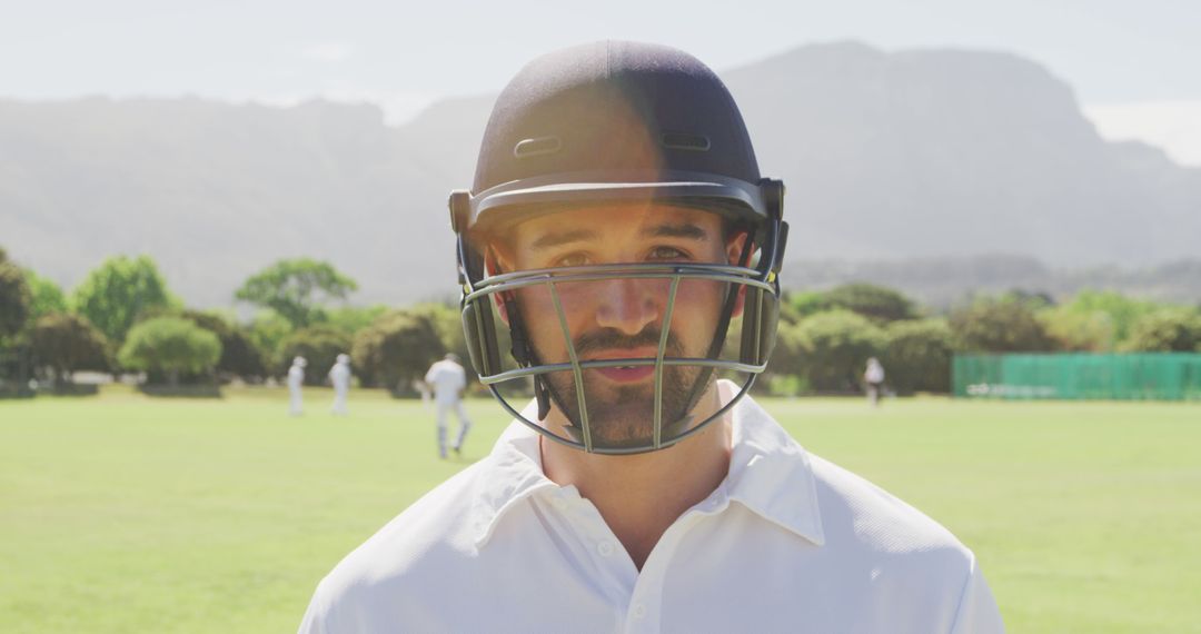 Cricket Player Wearing Helmet on Field on Sunny Day - Free Images, Stock Photos and Pictures on Pikwizard.com