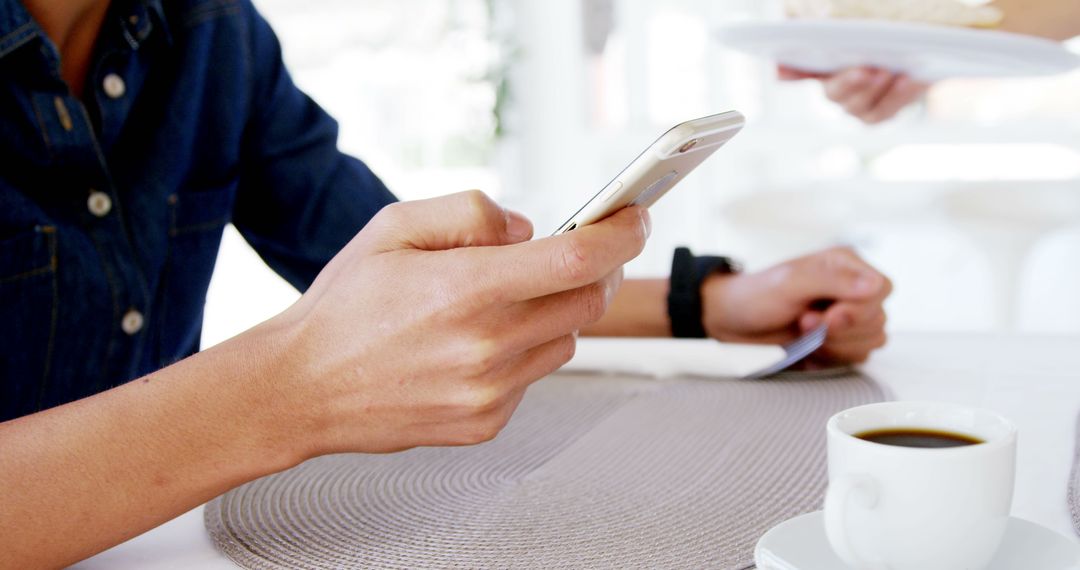 Close-Up of Person Using Smartphone at Table with Coffee - Free Images, Stock Photos and Pictures on Pikwizard.com