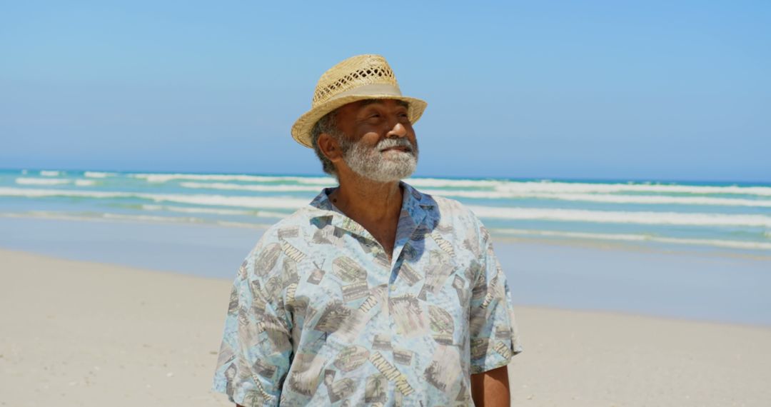 Senior Man Enjoying Tranquil Beach Walk on Sunny Day