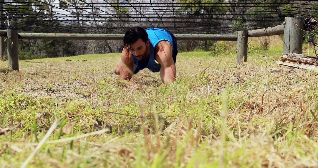 Athletic Man Crawling Through Obstacle Course on Grass - Free Images, Stock Photos and Pictures on Pikwizard.com