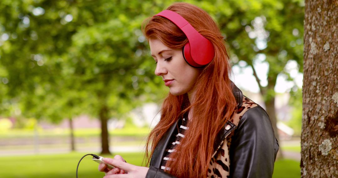 Young Woman in Red Headphones Using Smartphone in Park - Free Images, Stock Photos and Pictures on Pikwizard.com