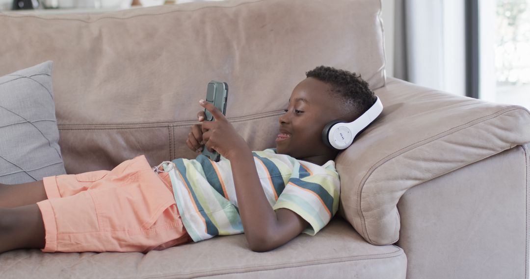 Boy Relaxing with Headphones and Smartphone on Couch