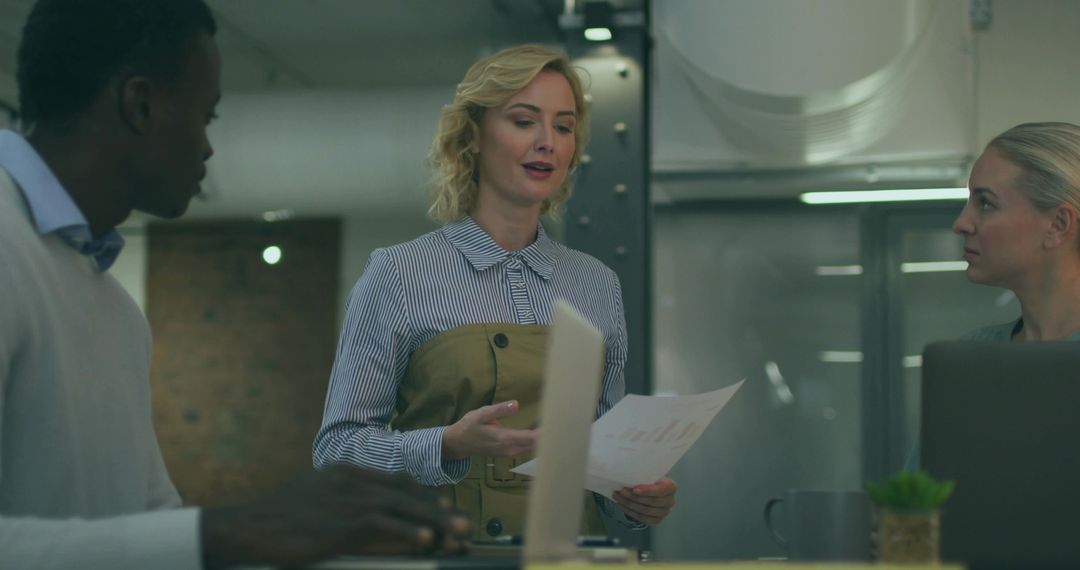 Diverse Team Analyzing Business Data in Modern Industrial Office