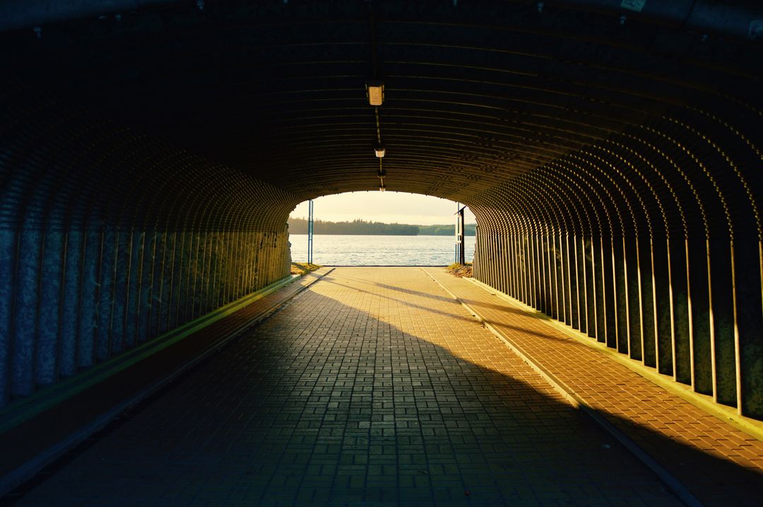 Sunset View from Tunnel Overlooking Lake with Brick Pathway - Free Images, Stock Photos and Pictures on Pikwizard.com