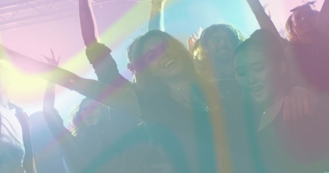 Smiling Woman Dancing in Crowded Club Under Colorful Stage Lights and Haze