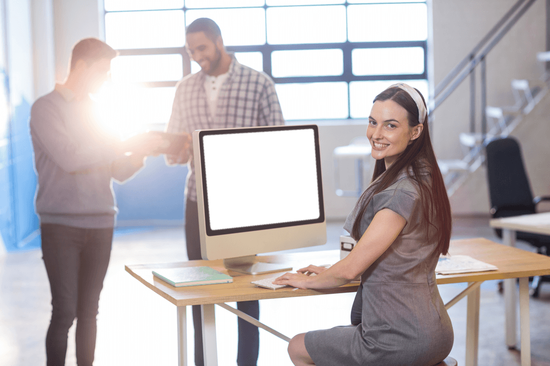 Businesswoman Sitting Confidently at Transparent Computer Desk in Office
