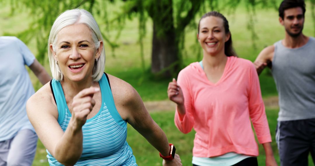 Group of Multi-Generational Adults Jogging in Park