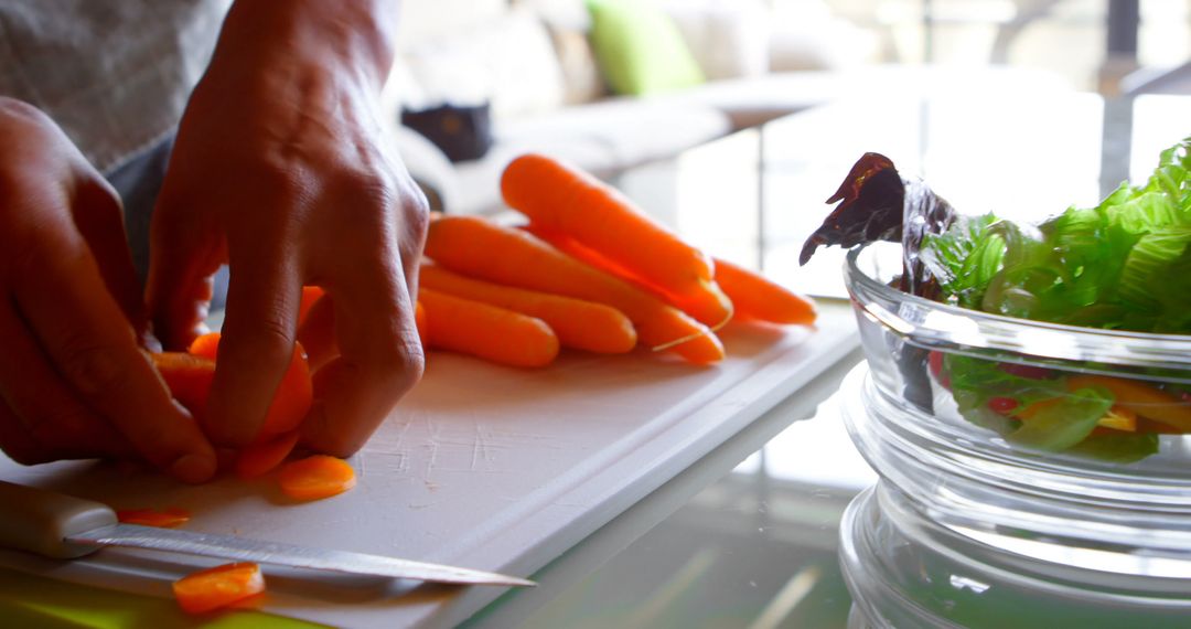 Person Chopping Carrots for a Fresh Salad on Cutting Board - Free Images, Stock Photos and Pictures on Pikwizard.com