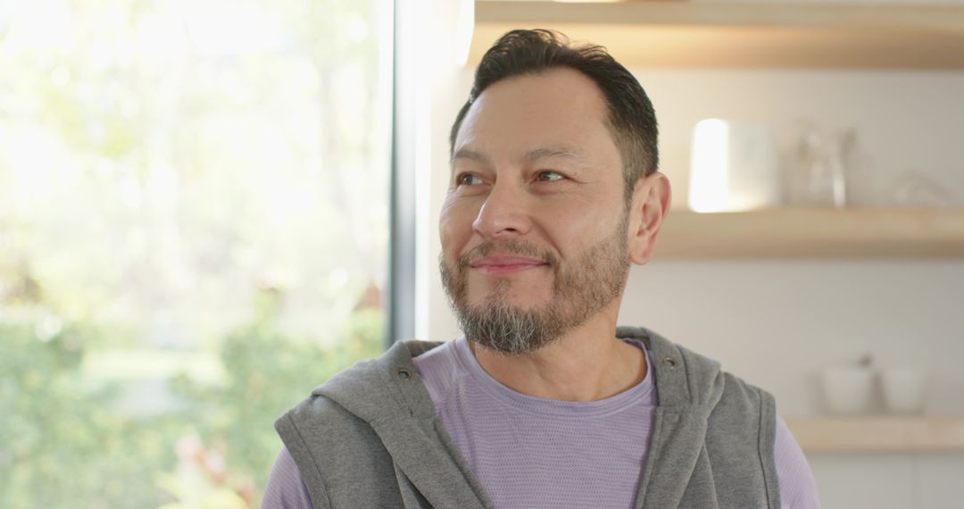 Mature Man Standing by Window in Modern Kitchen