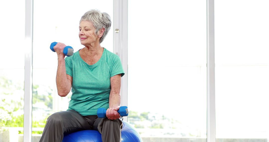 Senior Woman Exercising with Dumbbells on Stability Ball - Free Images, Stock Photos and Pictures on Pikwizard.com