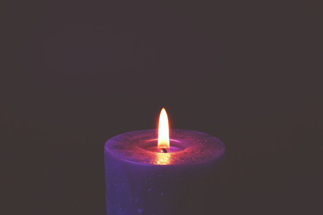 Serene Purple Candle Burning in the Darkness
