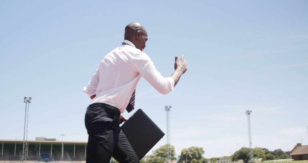 Businessman Sprinting on Running Track with Briefcase