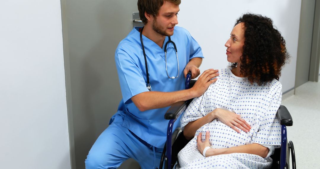 Nurse Assisting Pregnant Woman in Hospital Wheelchair - Free Images, Stock Photos and Pictures on Pikwizard.com